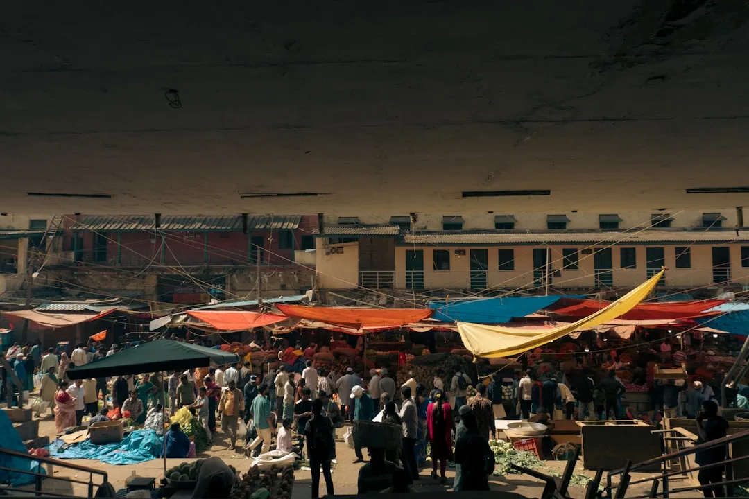 Crowded outdoor market with colorful tents and stalls at night