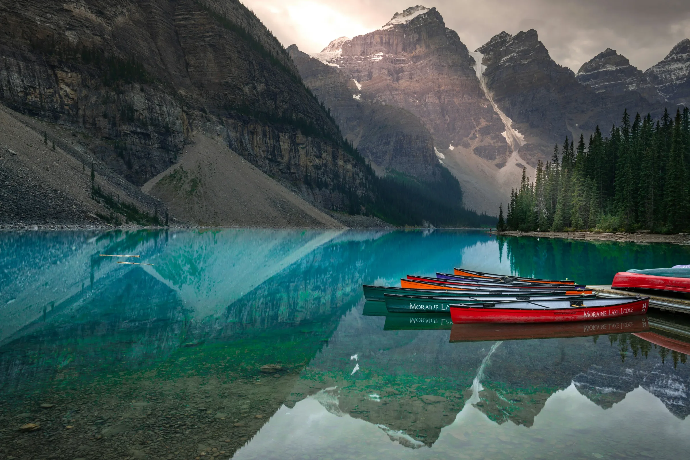 Moraine Lake in Banff National Park with colorful canoes and the Rocky Mountains