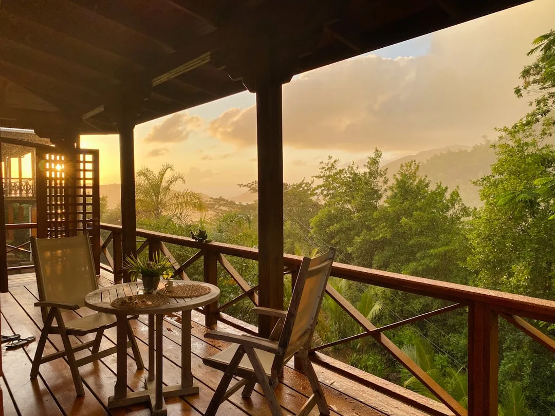Holzterrasse einer Eco-Lodge mit Ausblick über tropischen Regenwald bei Abenddämmerung