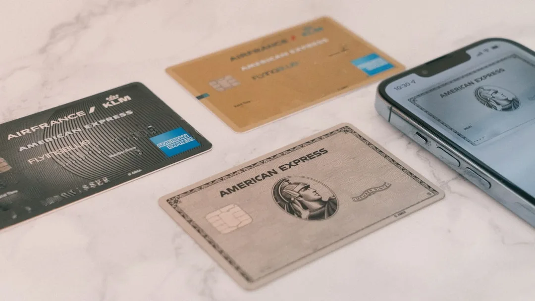 Multiple credit cards and a smartphone on white marble background