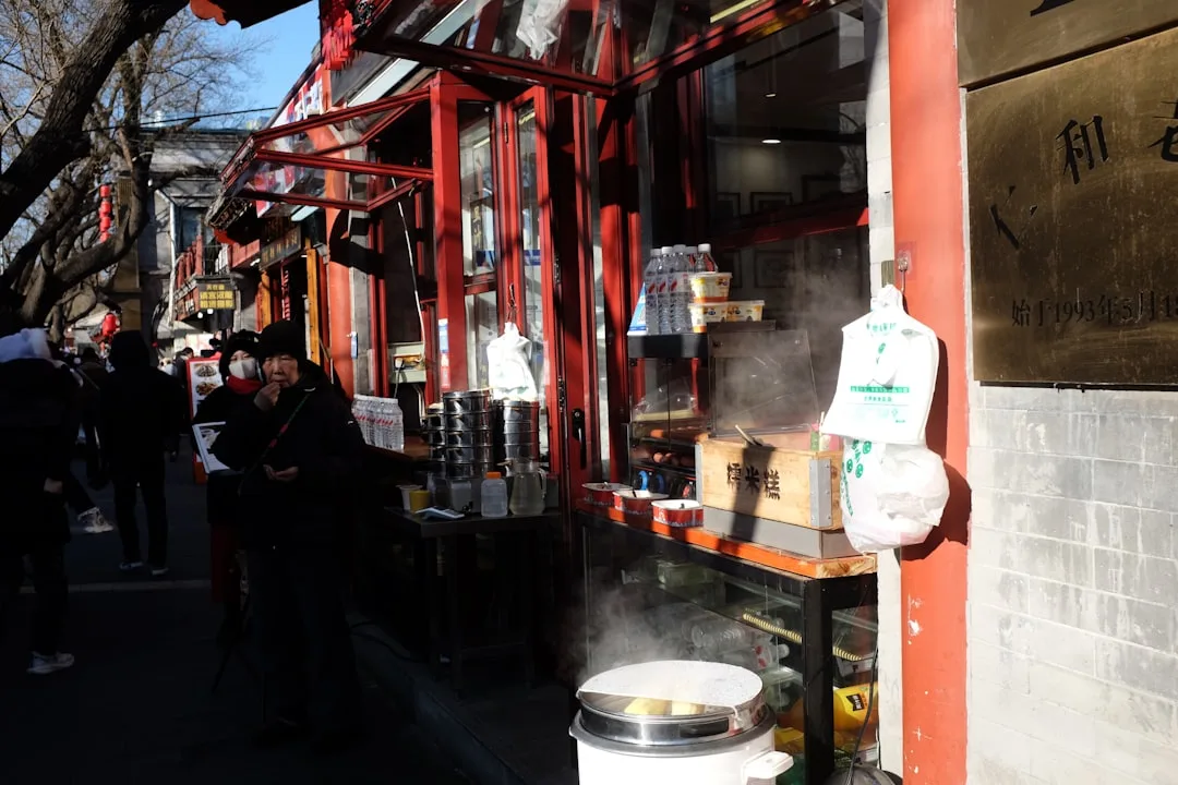 Street vendor selling steaming food at a red kiosk in China